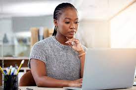 image of a black girl in front of her laptop while thinking